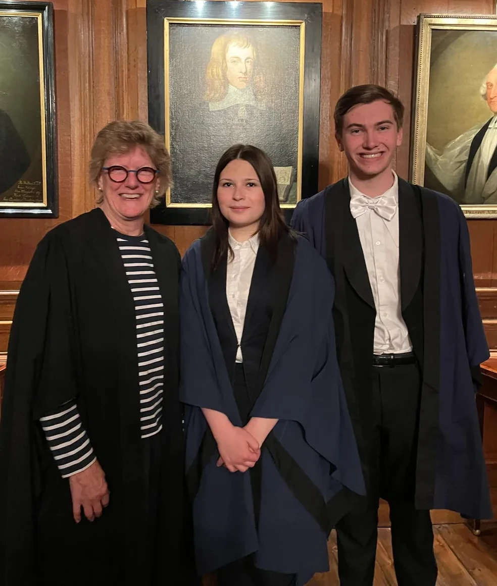 Three people standing together indoors